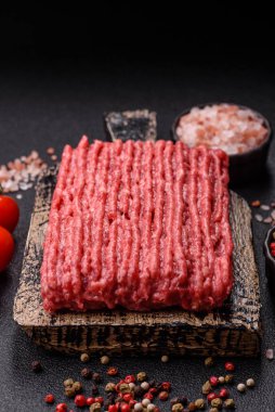 Koyu beton arka planda çiğ et veya tuzlu ve baharatlı domuz eti.