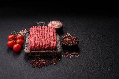 Koyu beton arka planda çiğ et veya tuzlu ve baharatlı domuz eti.