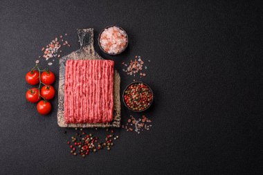 Koyu beton arka planda çiğ et veya tuzlu ve baharatlı domuz eti.