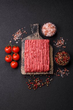 Koyu beton arka planda çiğ et veya tuzlu ve baharatlı domuz eti.