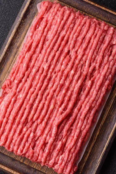 Koyu beton arka planda çiğ et veya tuzlu ve baharatlı domuz eti.