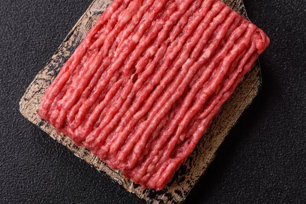 Koyu beton arka planda çiğ et veya tuzlu ve baharatlı domuz eti.