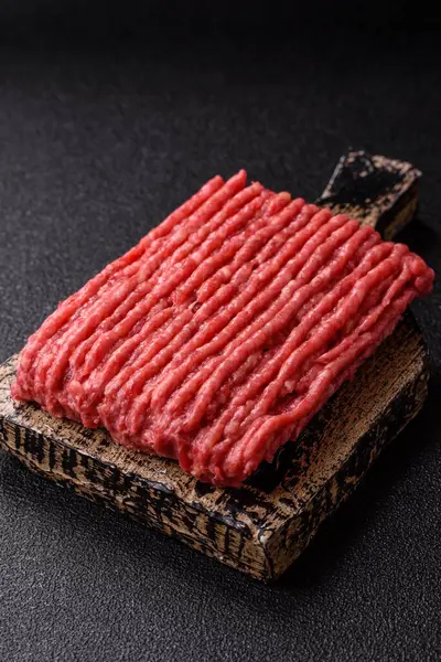 Koyu beton arka planda çiğ et veya tuzlu ve baharatlı domuz eti.