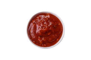 Beyaz arka planda seramik sos teknesinde tuzlu ve baharatlı kırmızı sos veya ketçap.