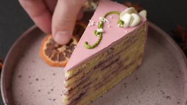 Koyu beton arka planda çilek aromalı pembe katmanlı bir pasta.