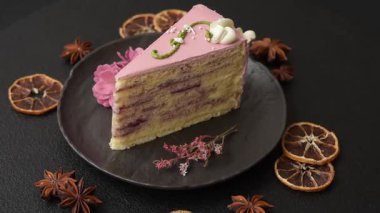 Koyu beton arka planda çilek aromalı pembe katmanlı bir pasta.