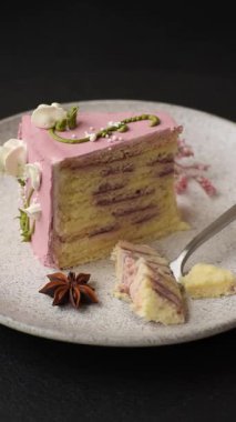 Koyu beton arka planda çilek aromalı pembe katmanlı bir pasta.