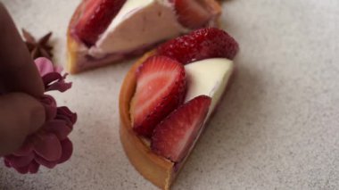 Çilek parçalı yuvarlak tatlı tart ve koyu beton arka planda krema