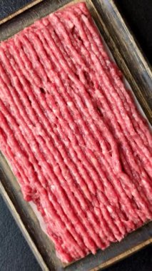 Koyu beton arka planda çiğ et veya tuzlu ve baharatlı domuz eti.