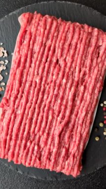 Koyu beton arka planda çiğ et veya tuzlu ve baharatlı domuz eti.