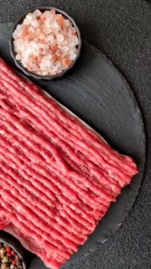 Koyu beton arka planda çiğ et veya tuzlu ve baharatlı domuz eti.