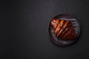 Koyu beton arka planda çikolatalı taze kruvasan.