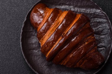 Koyu beton arka planda çikolatalı taze kruvasan.