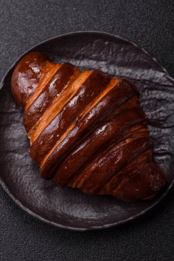 Koyu beton arka planda çikolatalı taze kruvasan.