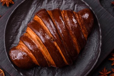 Koyu beton arka planda çikolatalı taze kruvasan.