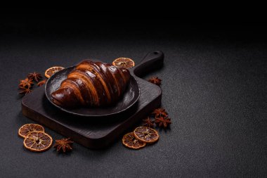 Koyu beton arka planda çikolatalı taze kruvasan.