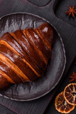 Koyu beton arka planda çikolatalı taze kruvasan.