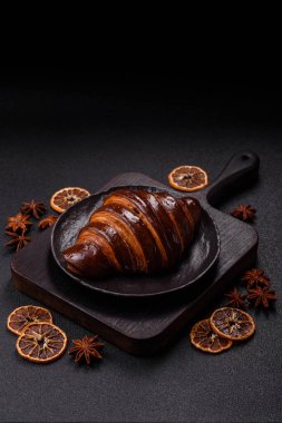Koyu beton arka planda çikolatalı taze kruvasan.