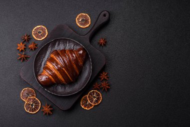 Koyu beton arka planda çikolatalı taze kruvasan.