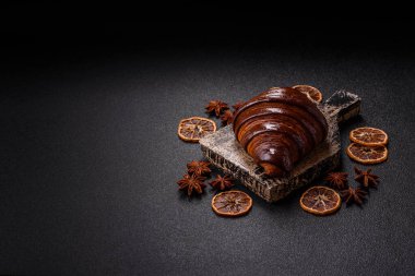Koyu beton arka planda çikolatalı taze kruvasan.