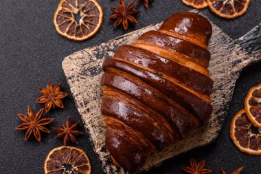 Koyu beton arka planda çikolatalı taze kruvasan.