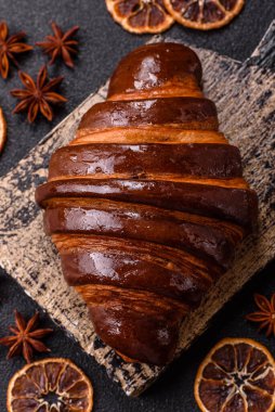 Koyu beton arka planda çikolatalı taze kruvasan.