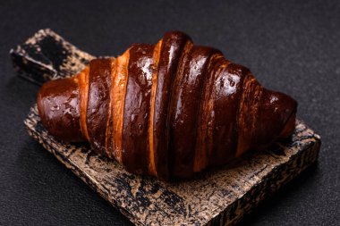 Koyu beton arka planda çikolatalı taze kruvasan.