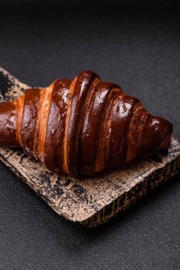 Koyu beton arka planda çikolatalı taze kruvasan.