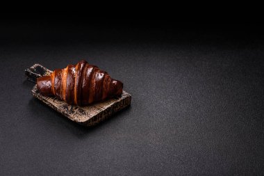 Koyu beton arka planda çikolatalı taze kruvasan.