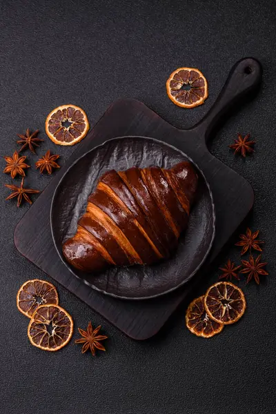 Koyu beton arka planda çikolatalı taze kruvasan.