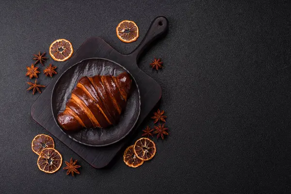 Koyu beton arka planda çikolatalı taze kruvasan.