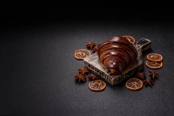 Koyu beton arka planda çikolatalı taze kruvasan.