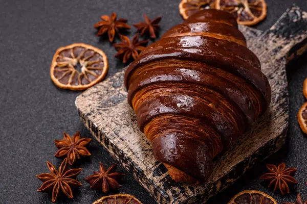 Koyu beton arka planda çikolatalı taze kruvasan.