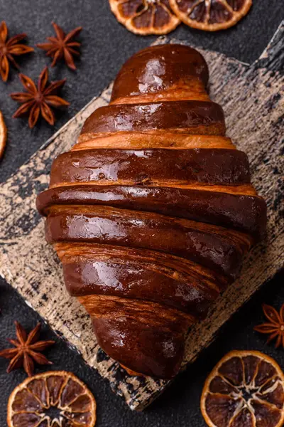 Koyu beton arka planda çikolatalı taze kruvasan.