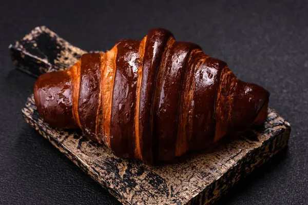 Koyu beton arka planda çikolatalı taze kruvasan.