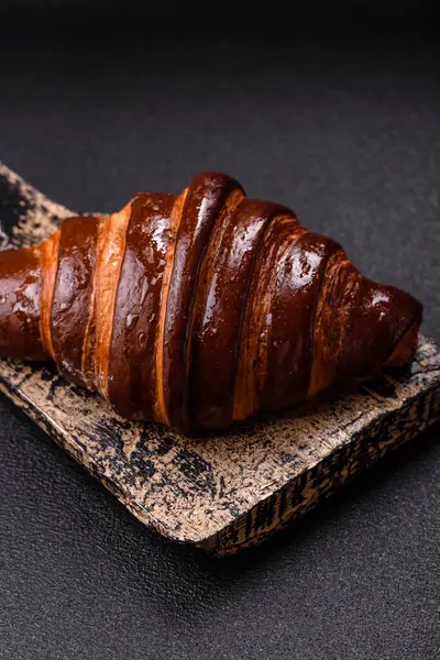 Koyu beton arka planda çikolatalı taze kruvasan.