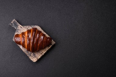 Koyu beton arka planda çikolatalı taze kruvasan.