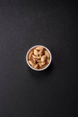 Koyu beton arka planda seramik kasede Brezilya fındık çekirdekleri