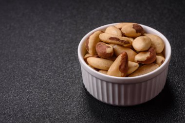 Koyu beton arka planda seramik kasede Brezilya fındık çekirdekleri