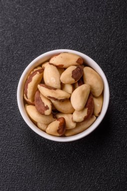 Koyu beton arka planda seramik kasede Brezilya fındık çekirdekleri