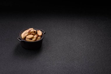 Koyu beton arka planda seramik kasede Brezilya fındık çekirdekleri