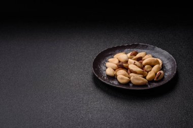Koyu beton arka planda seramik kasede Brezilya fındık çekirdekleri