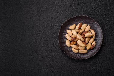 Koyu beton arka planda seramik kasede Brezilya fındık çekirdekleri