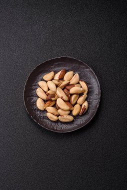 Koyu beton arka planda seramik kasede Brezilya fındık çekirdekleri