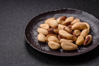 Koyu beton arka planda seramik kasede Brezilya fındık çekirdekleri