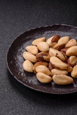 Koyu beton arka planda seramik kasede Brezilya fındık çekirdekleri