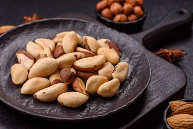 Koyu beton arka planda seramik kasede Brezilya fındık çekirdekleri