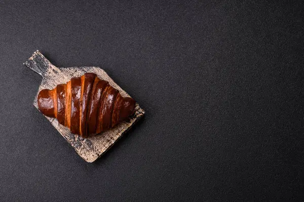 Koyu beton arka planda çikolatalı taze kruvasan.