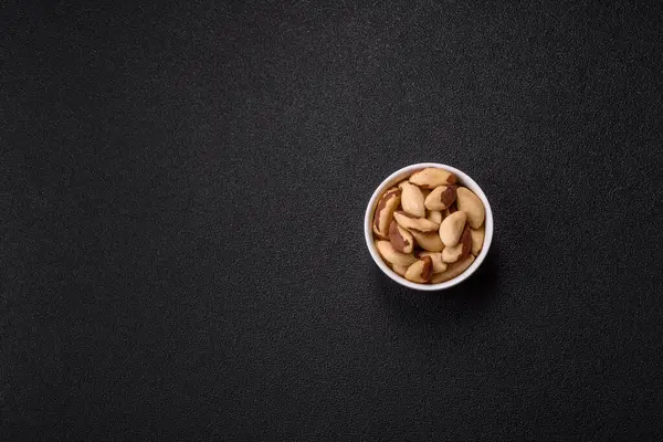 Koyu beton arka planda seramik kasede Brezilya fındık çekirdekleri