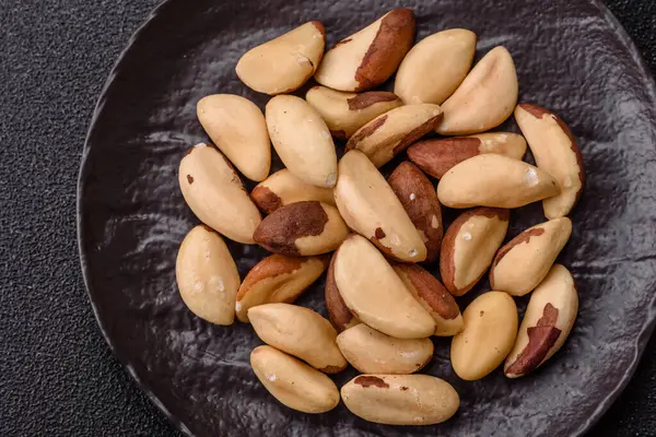 Koyu beton arka planda seramik kasede Brezilya fındık çekirdekleri